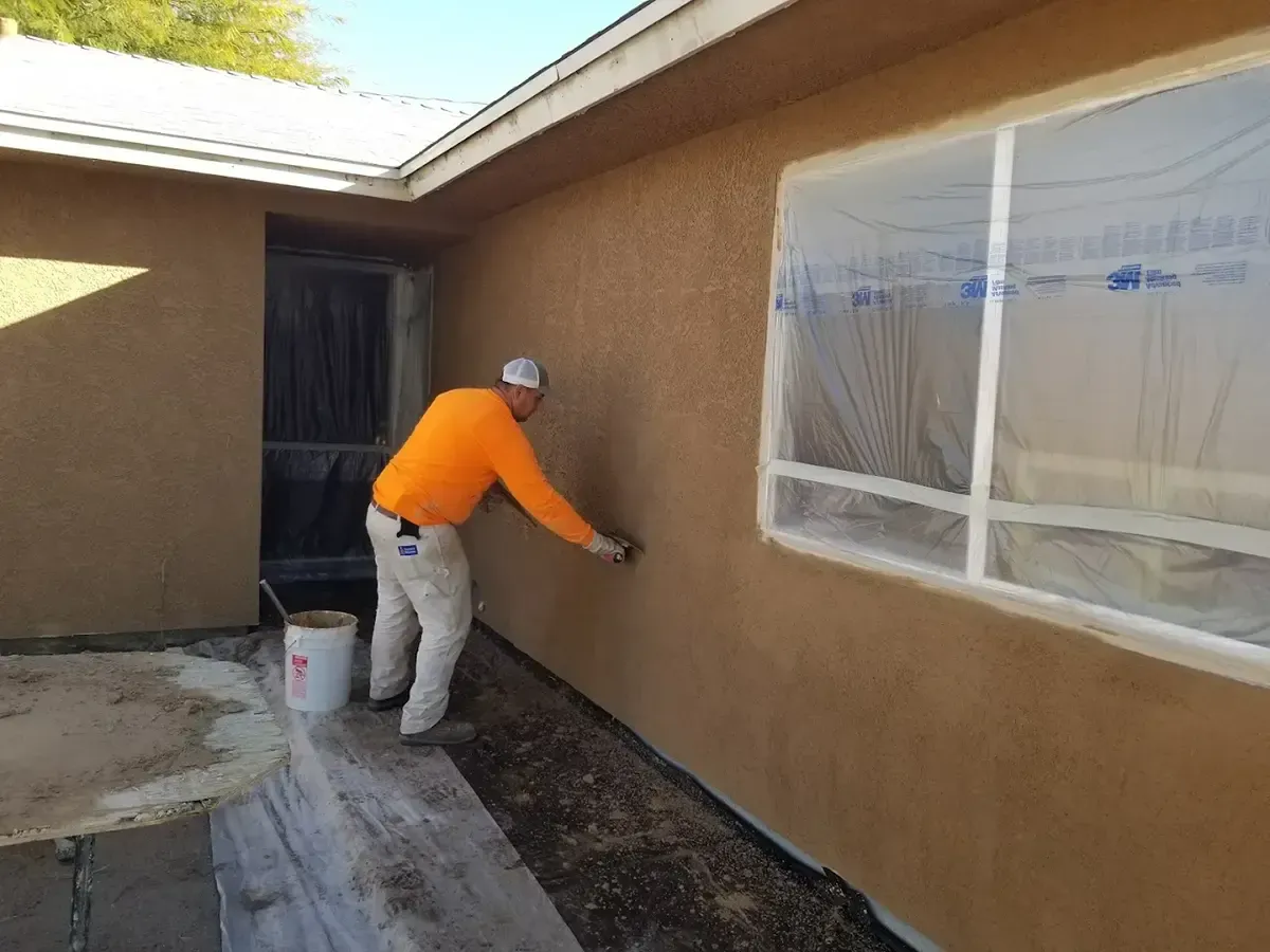 Man applying stucco to an exterior wall.