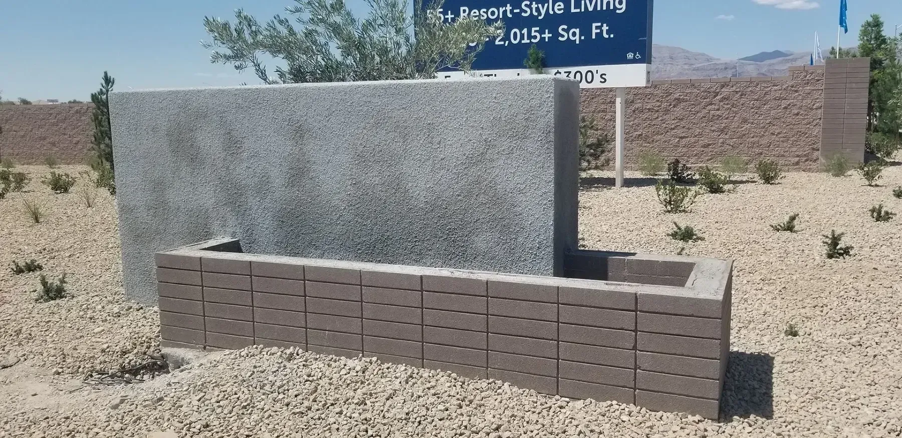 A two-tone decorative wall in a desert environment, likely for a new development.