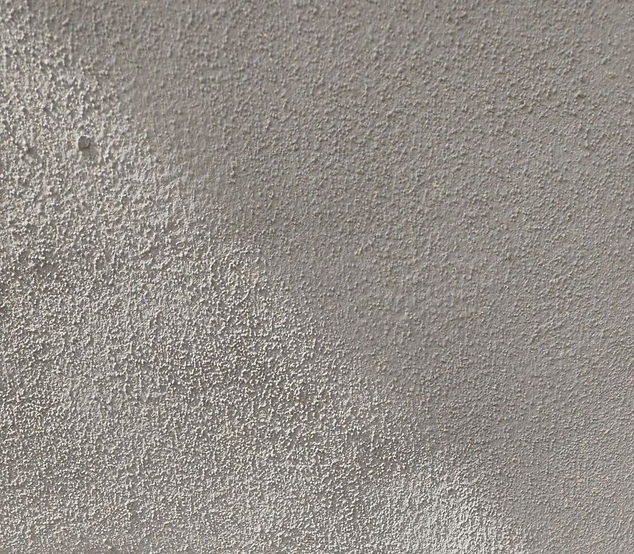 Close-up of a textured, light gray wall surface.