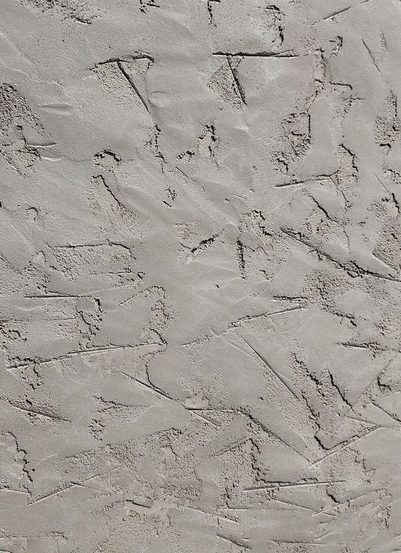 Textured light gray stucco wall with visible trowel marks.