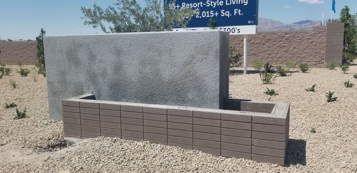 A modern architectural water feature made of brick and gray stone in a desert landscape.