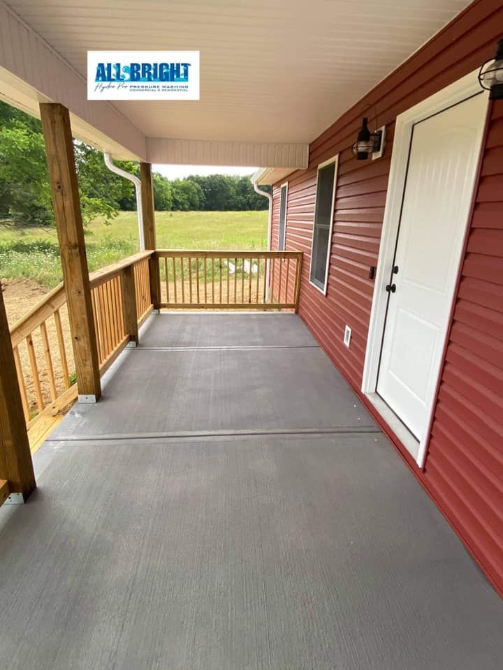 A red house with a concrete porch and a wooden railing.