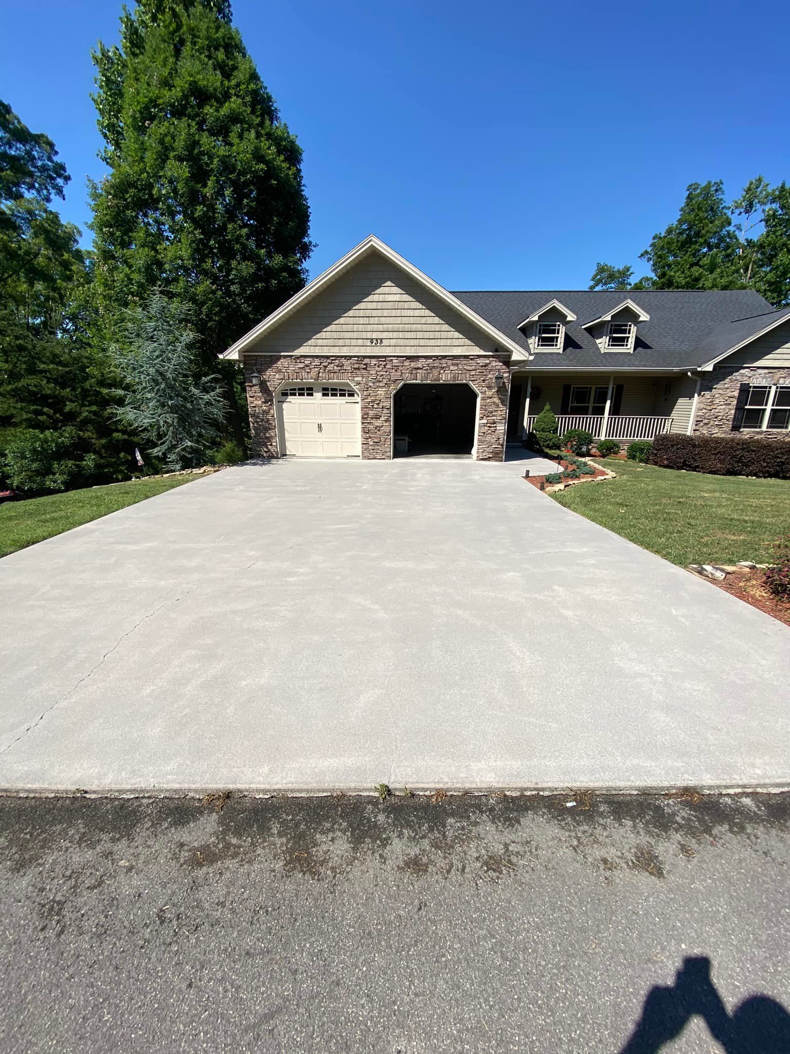 A large house with a concrete driveway leading to it.