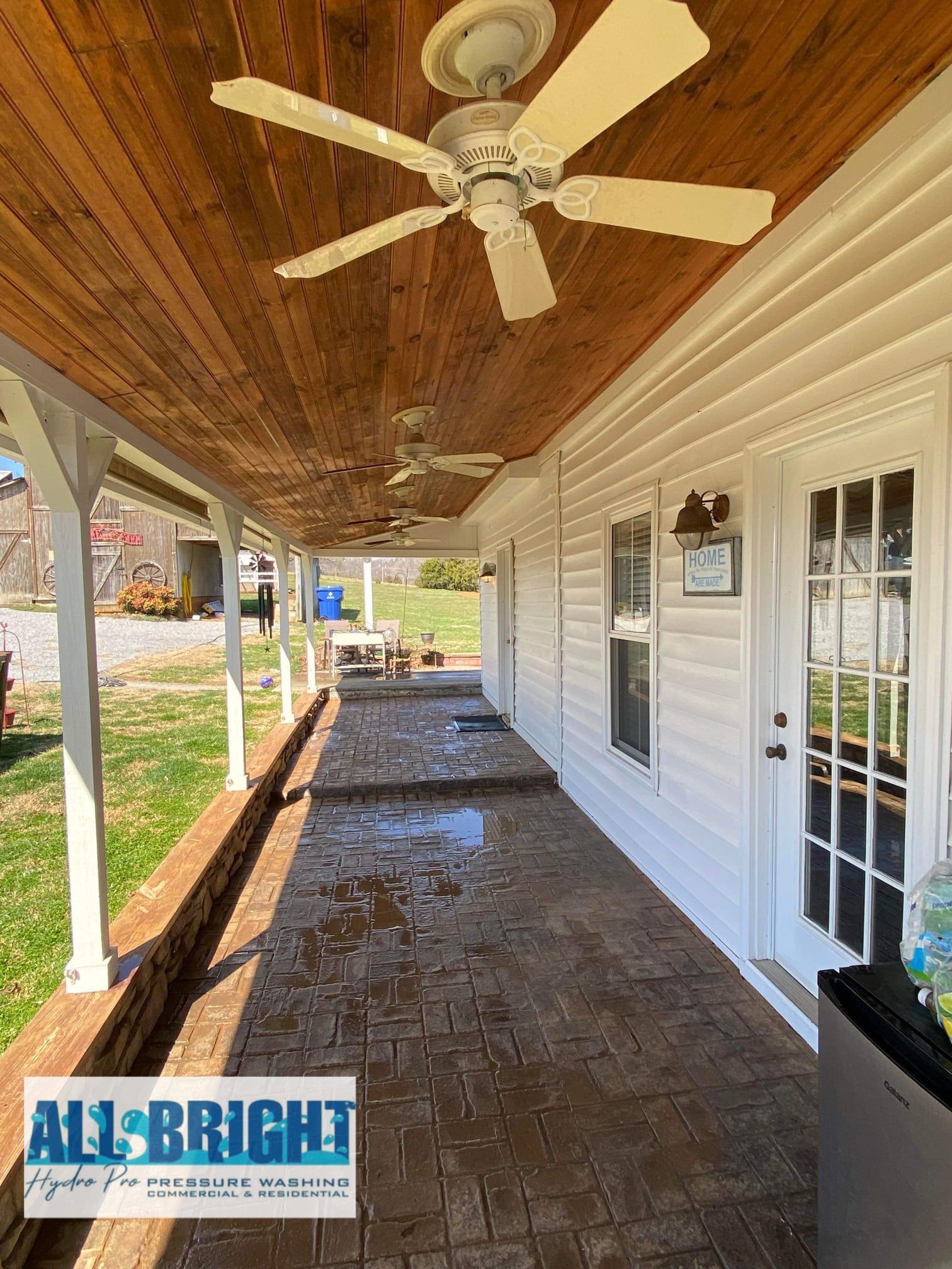 There is a ceiling fan on the porch of a house.