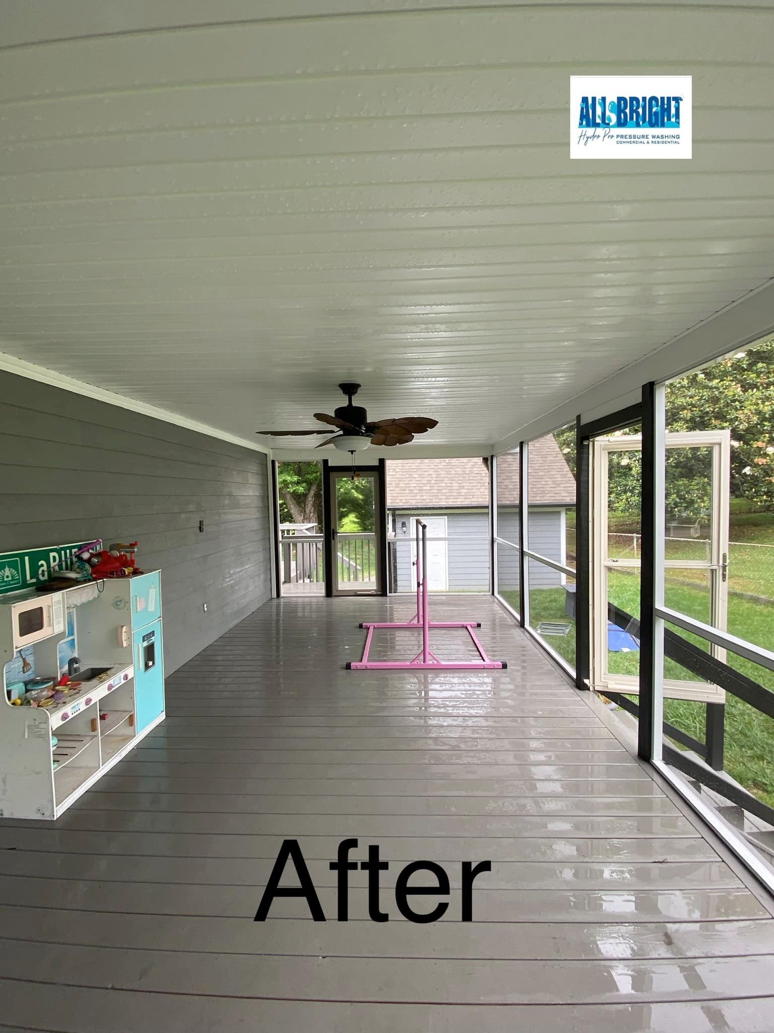 A picture of a screened in porch with a ceiling fan.