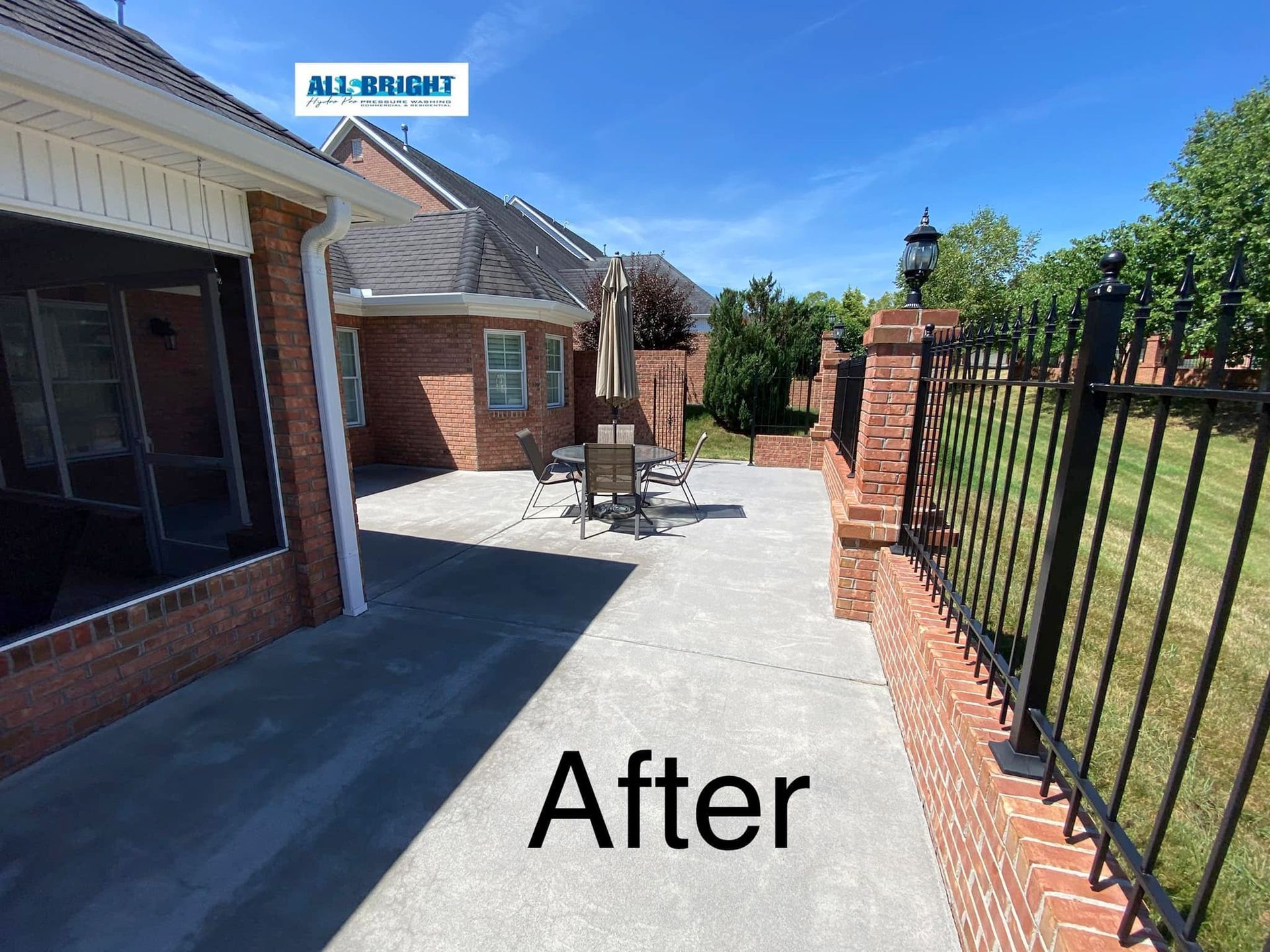 A picture of a patio with a fence and a brick wall.