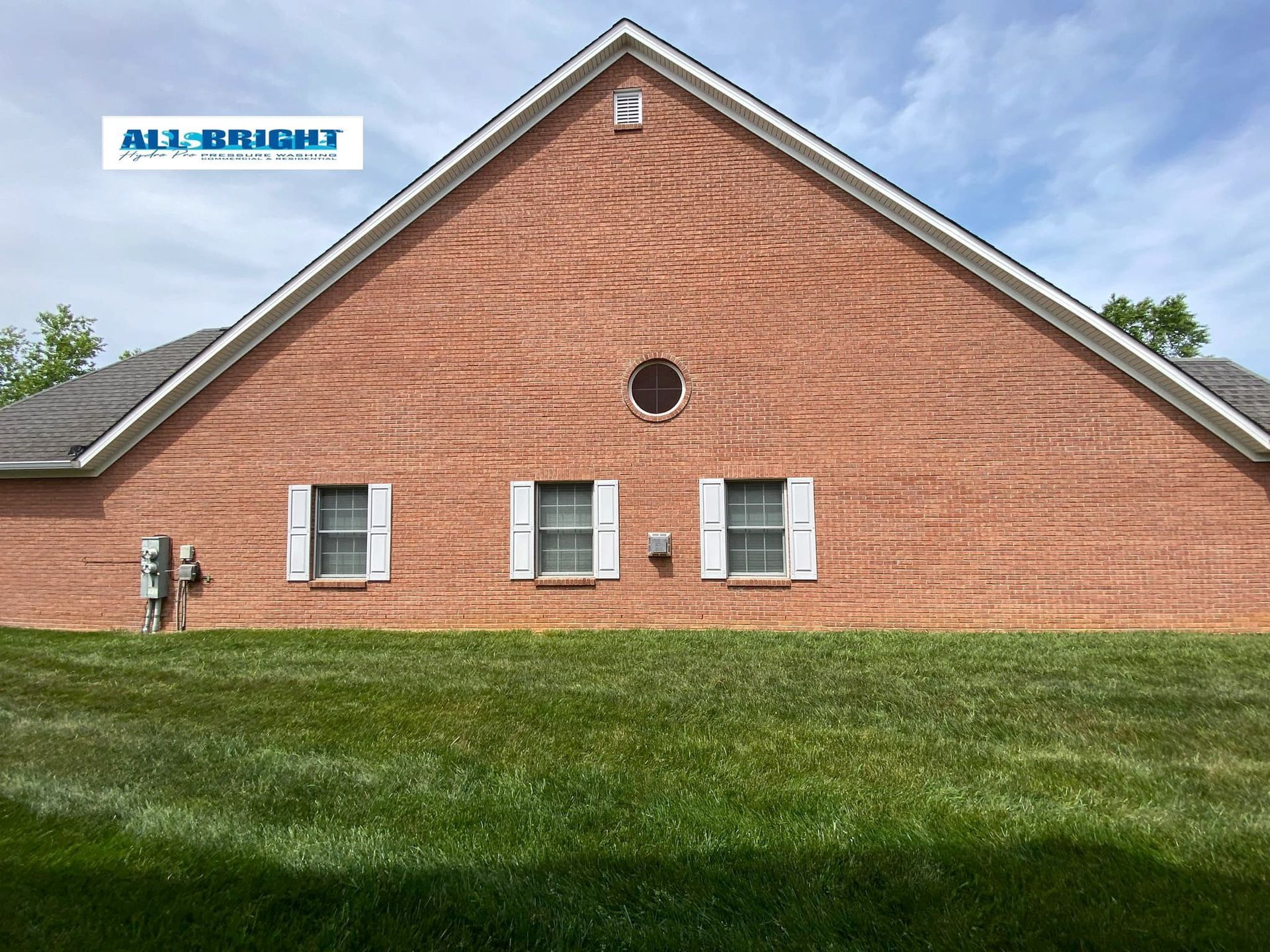 A red brick house with white shutters on the windows