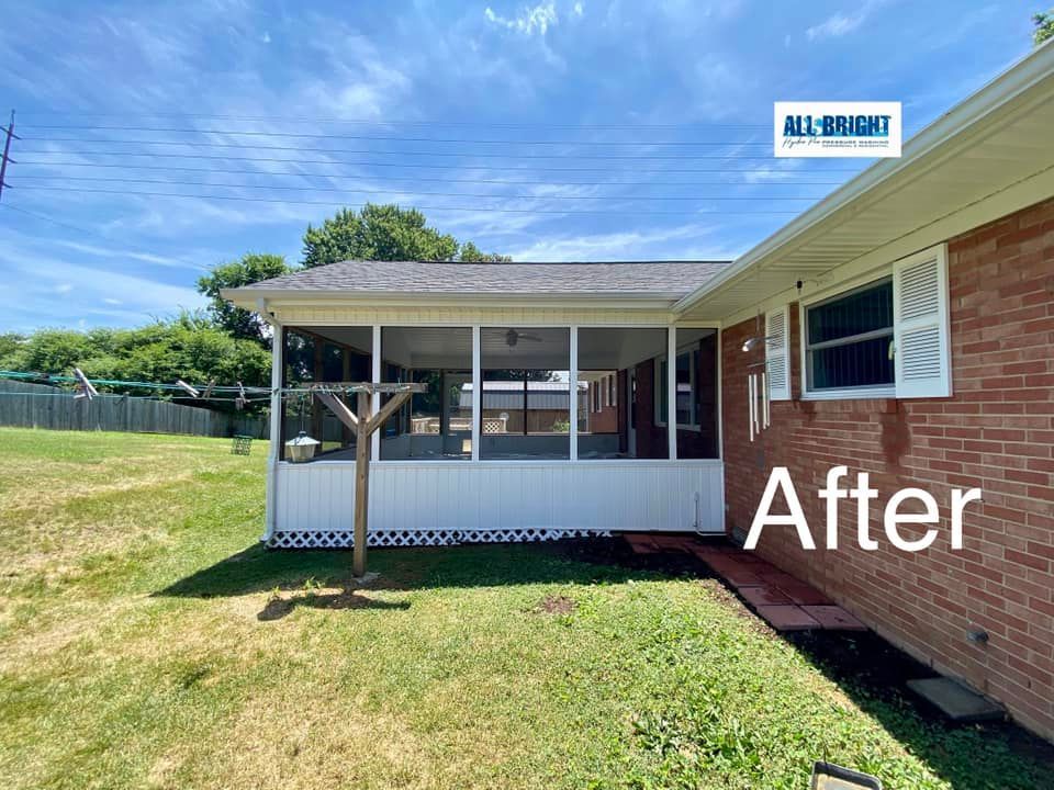 A picture of a screened in porch on a brick house.