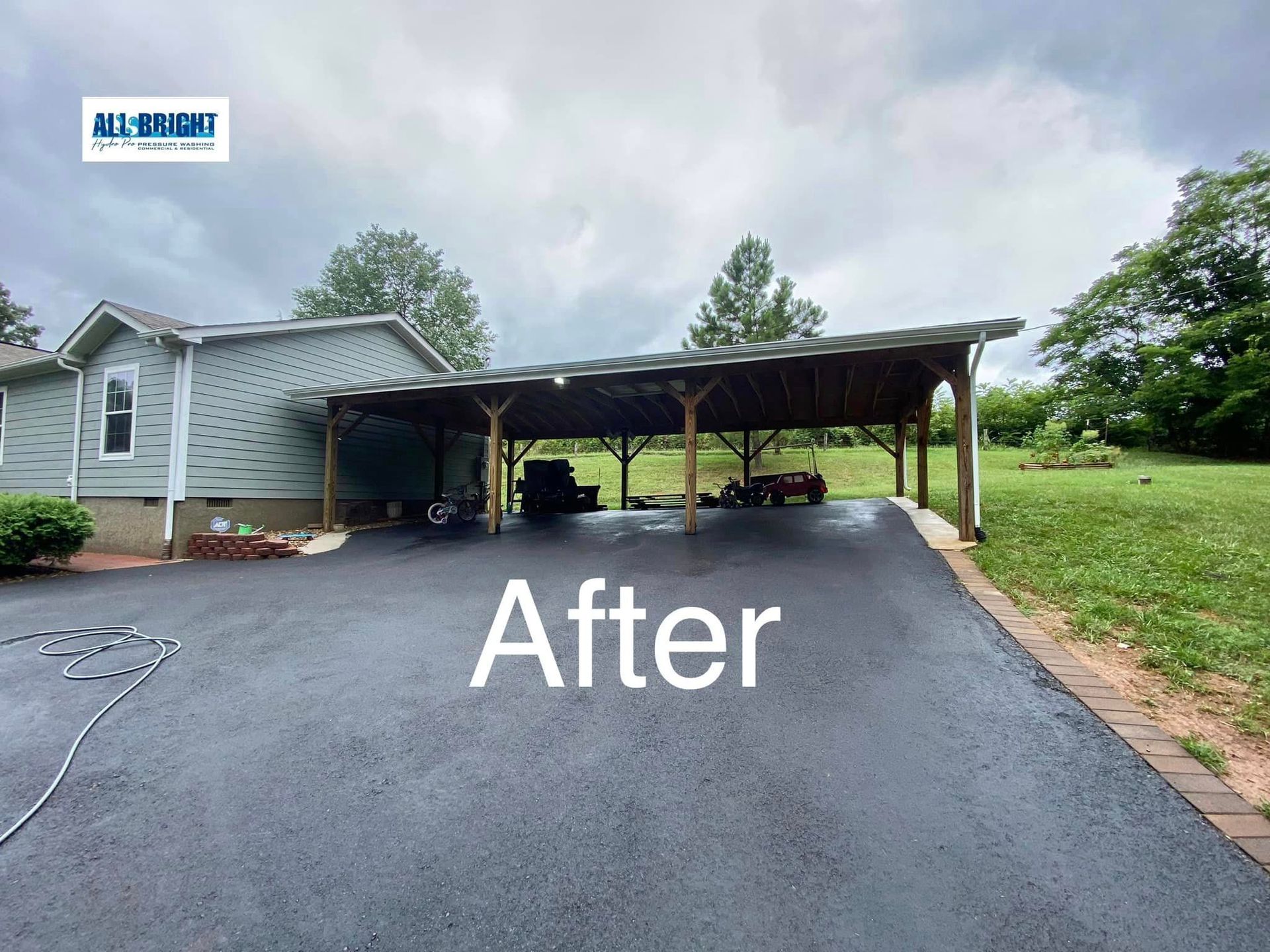 A picture of a driveway with a carport and a house in the background.