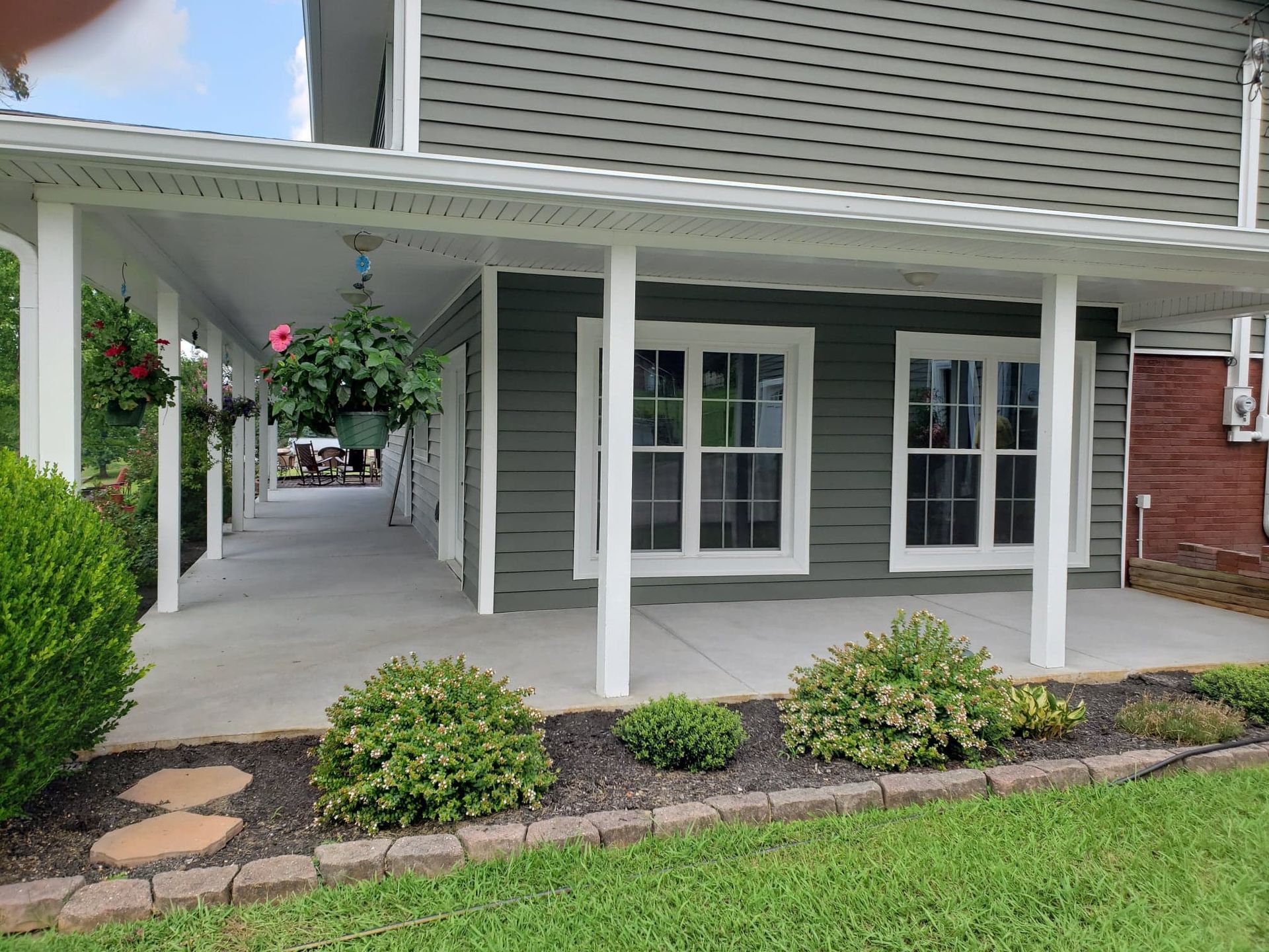 A house with a porch and a covered walkway leading to it.