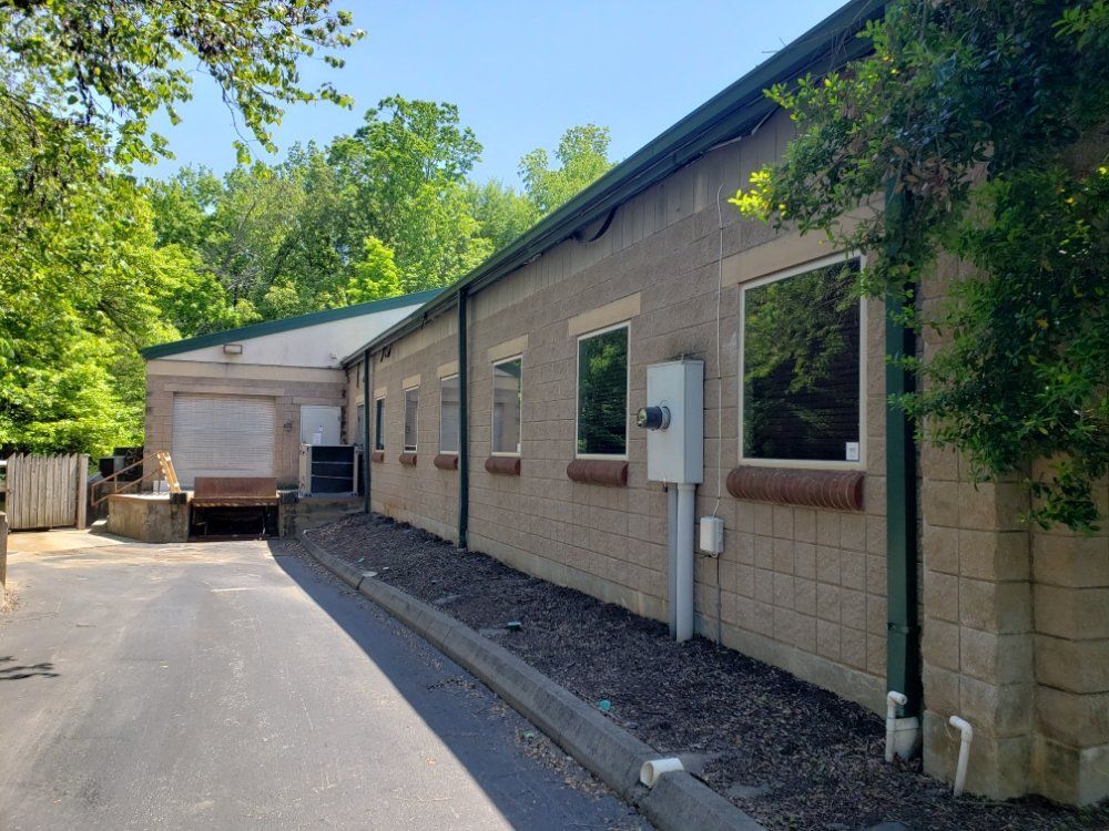 A brick building with a green roof and a lot of windows