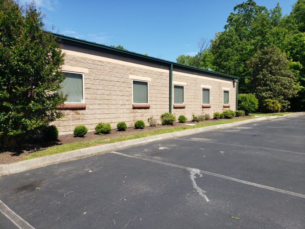A brick building with a parking lot in front of it
