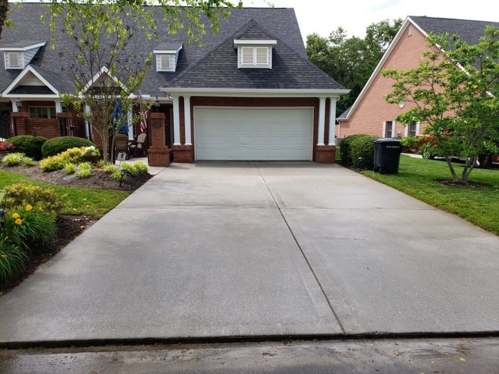 A driveway leading to a house with a garage door