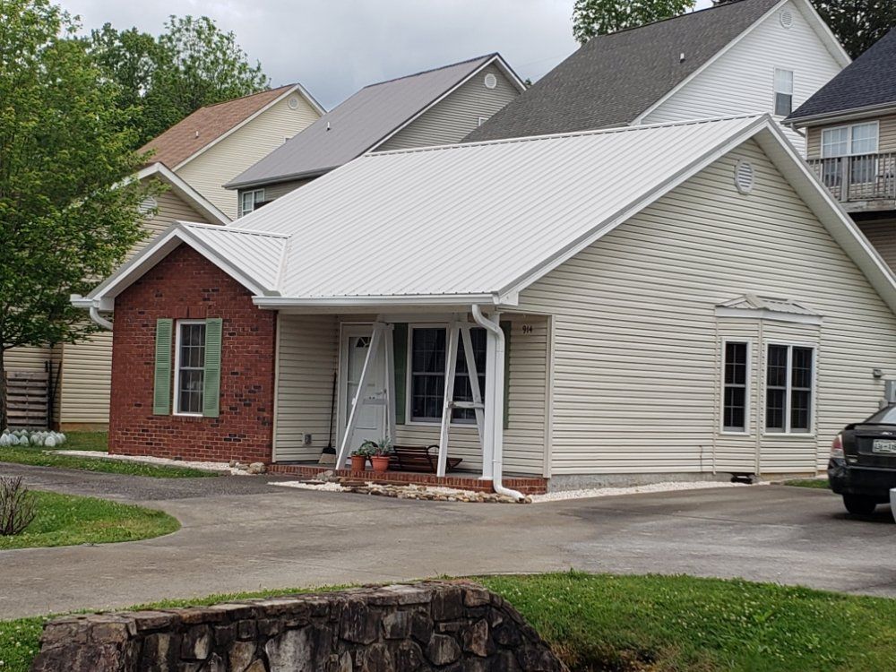 A house with a white roof is surrounded by other houses