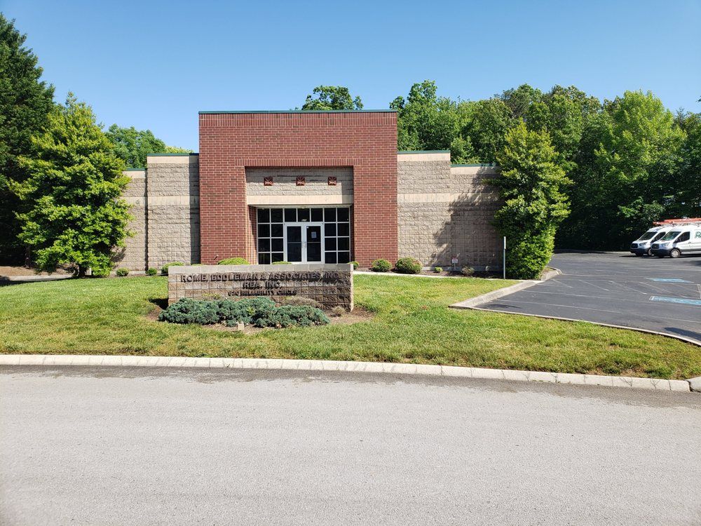 A large brick building with a sign in front of it