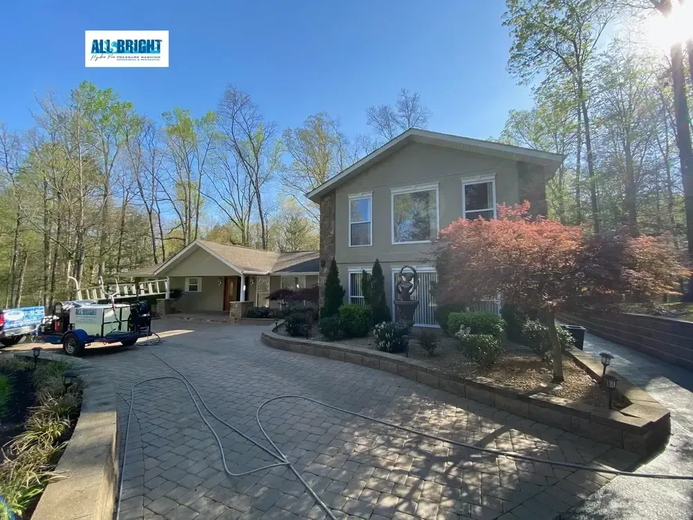A large house with a driveway and trees in front of it.