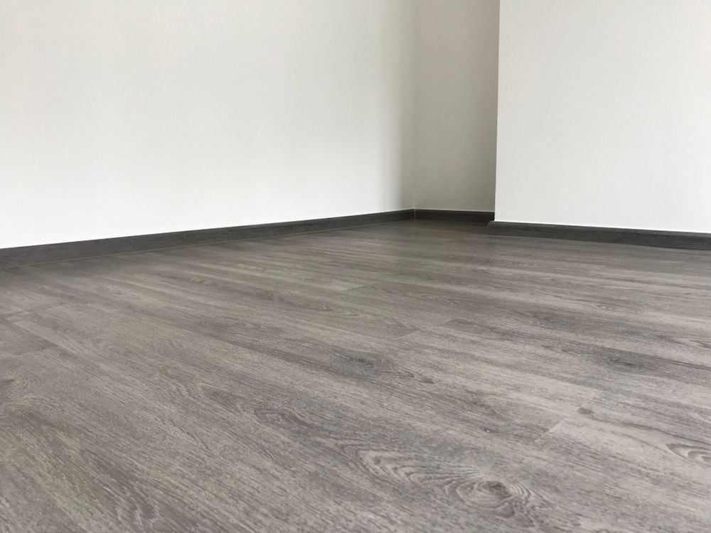 An Empty Room With A Wooden Floor And White Walls — Affordable Carpets Woolgoolga In Woolgoolga, NSW