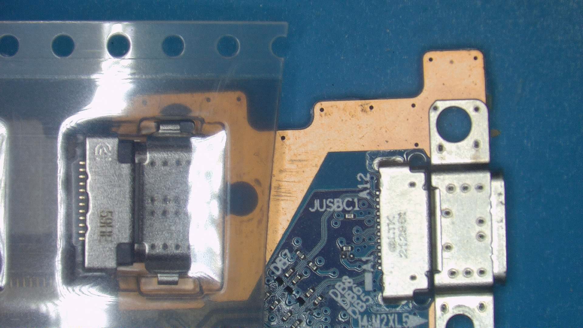 Puerto USB‑C nuevo junto al conector original en placa de notebook durante reemplazo con soldadura de precisión en CM Informática Bahía Blanca.