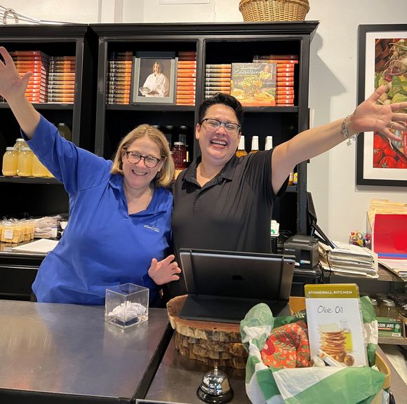 A man and a woman are posing for a picture with their arms outstretched