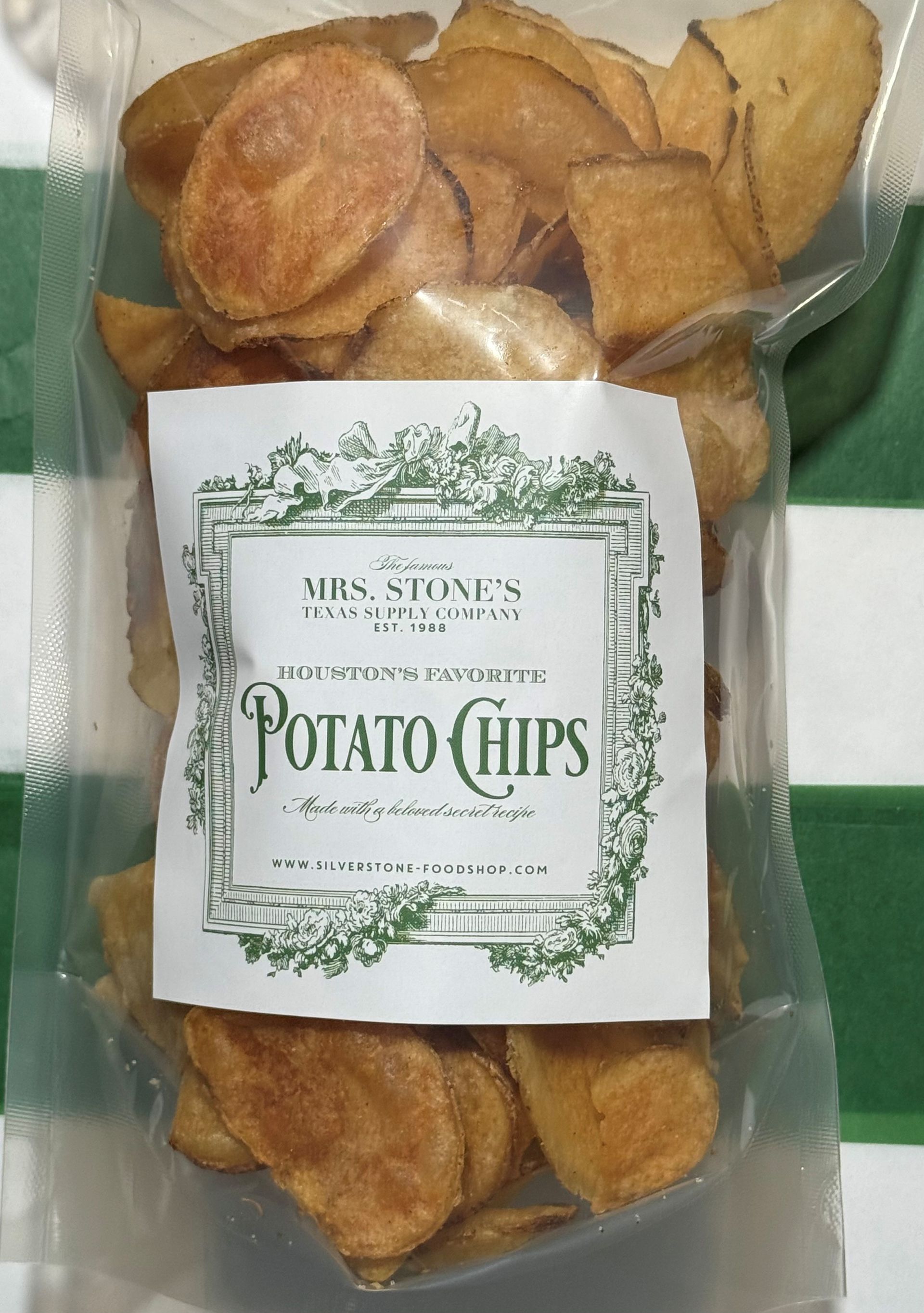 Bag of Mrs. Stone's Potato Chips, golden brown chips visible through a clear plastic bag. Green label.