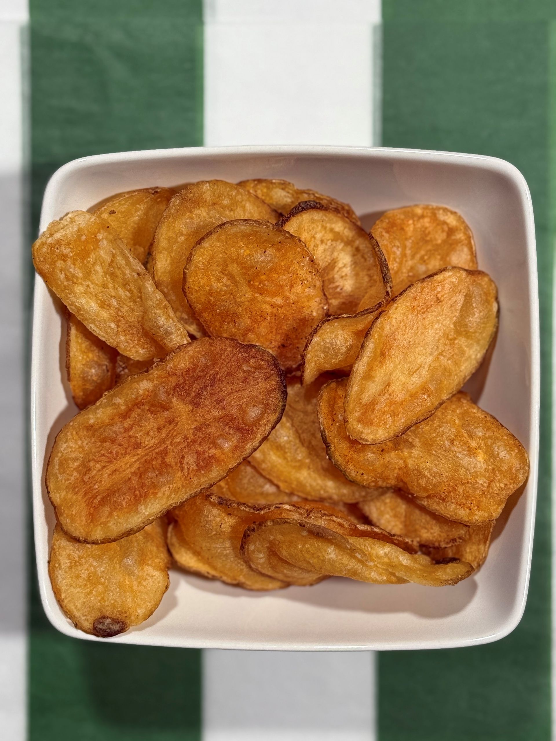 Bag of Mrs. Stone's Potato Chips, golden brown chips visible through a clear plastic bag. Green label.