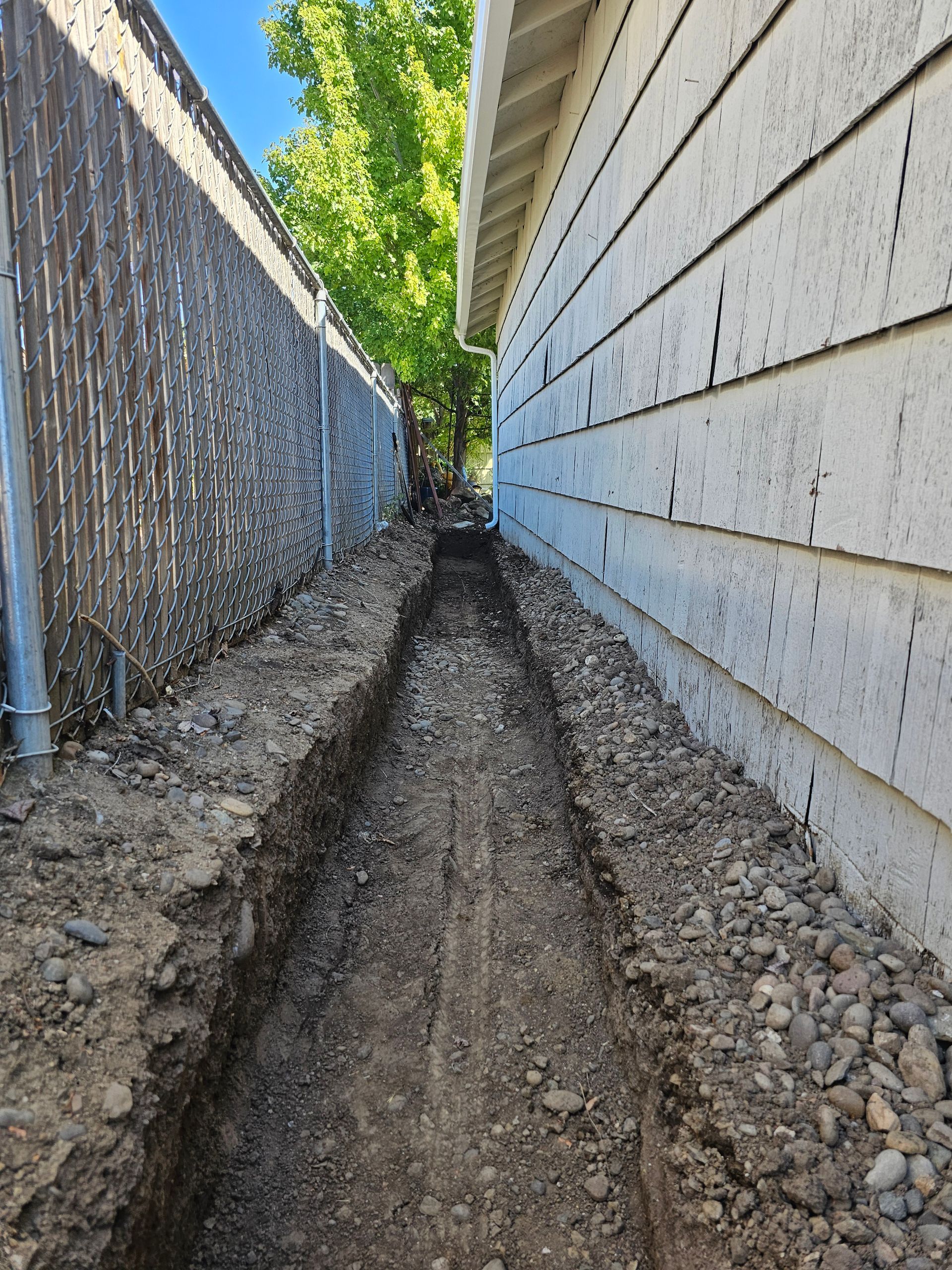 A trench installed next to a house foundation to divert water in Medford, Oregon