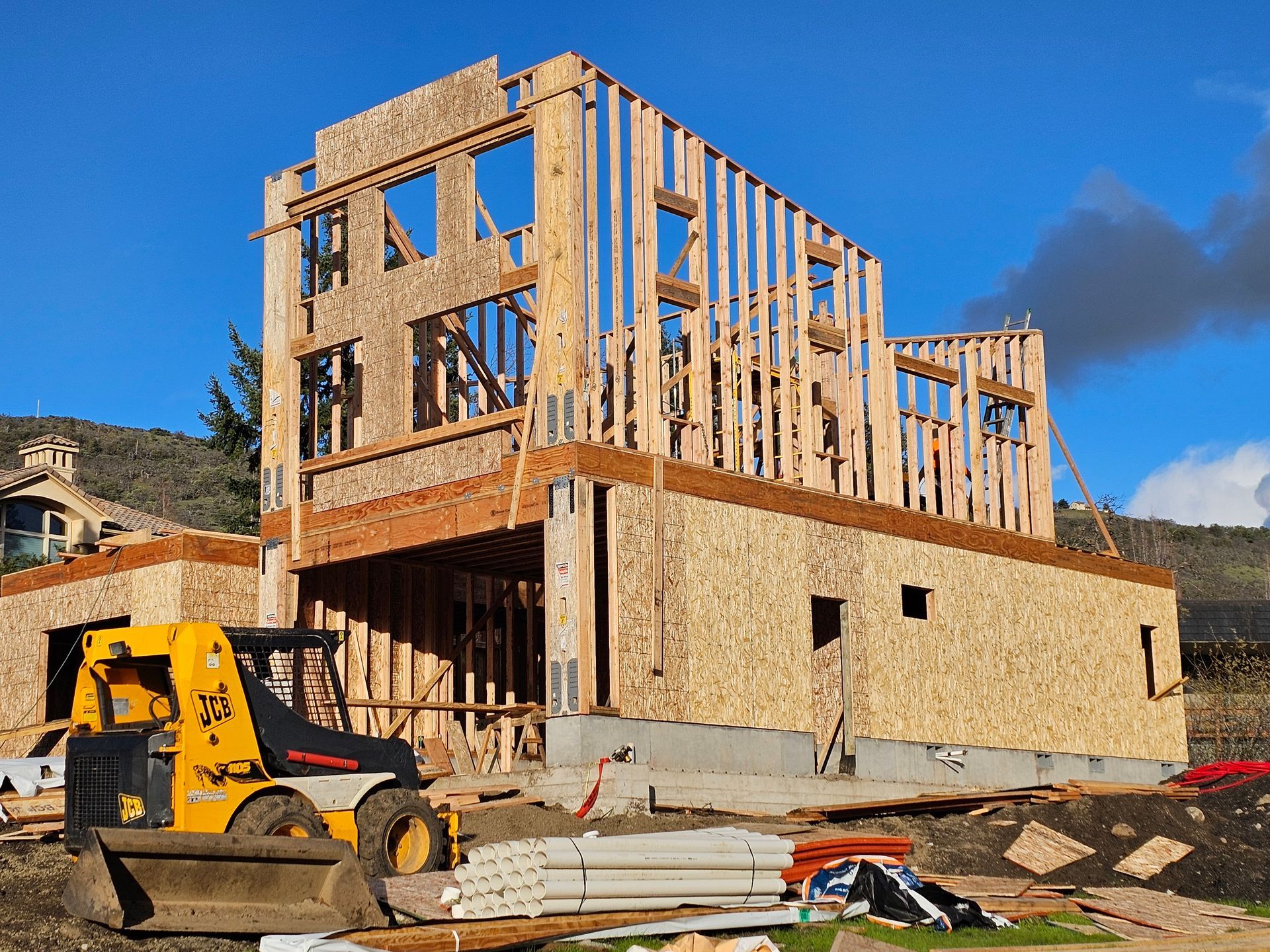 A house is being built with a bulldozer in front of it in Medford, Oregon