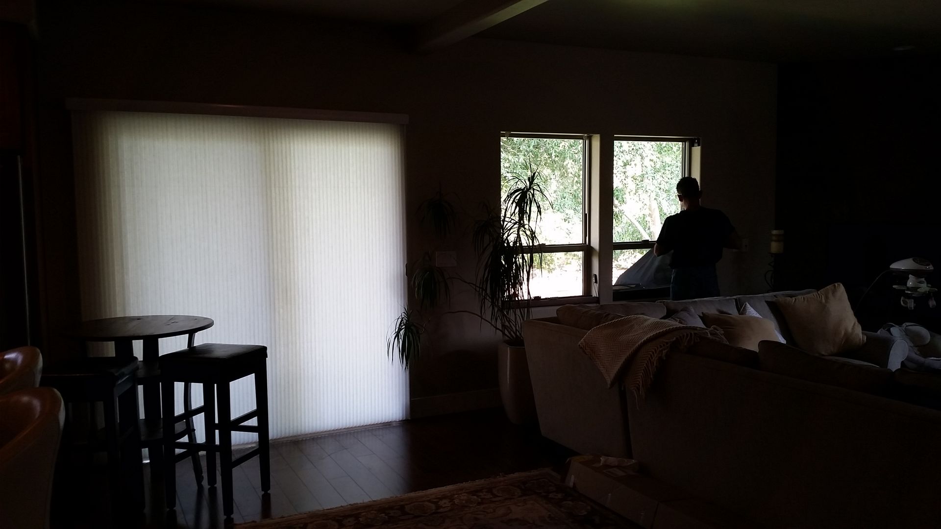 a dark living room with a window with  cellular shades
