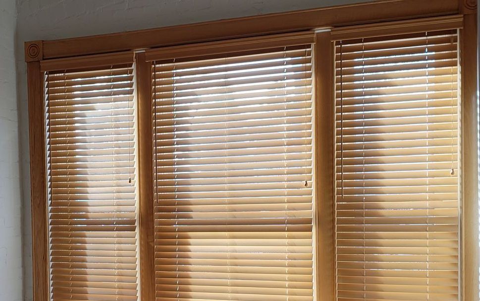 a close up of a wood blinds on a window .