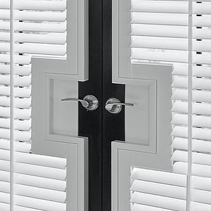 A pair of white shutters with black handles on a door.