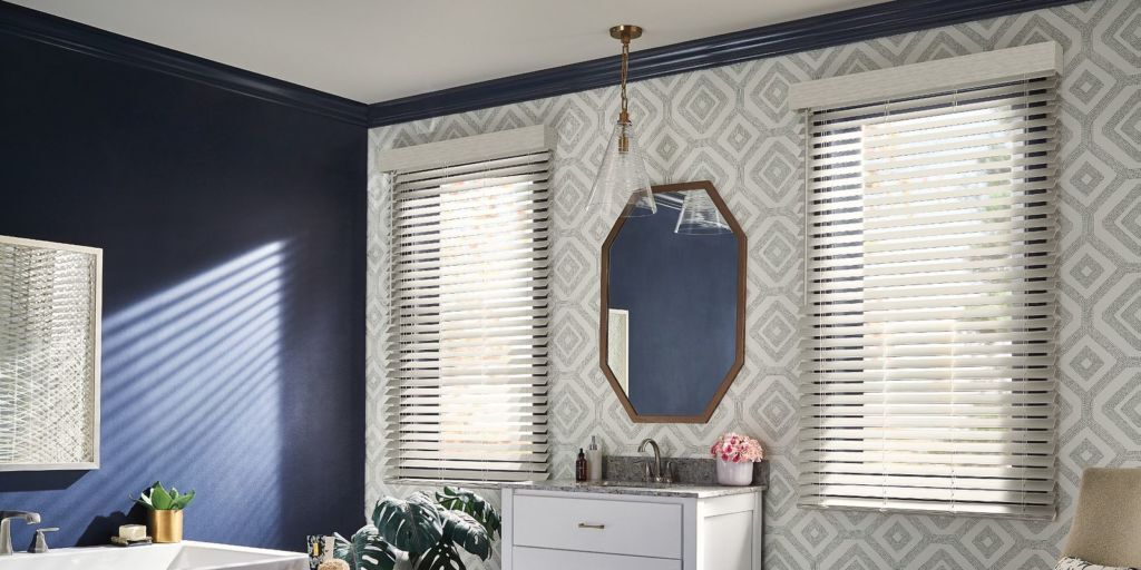 a bathroom with blue walls and white composite / faux wood blinds
