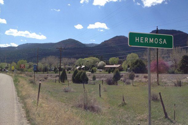 a green sign on the side of a road says Hermosa Colorado