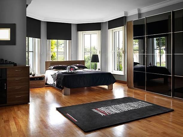 A bedroom with a large bed and a rug on the floor