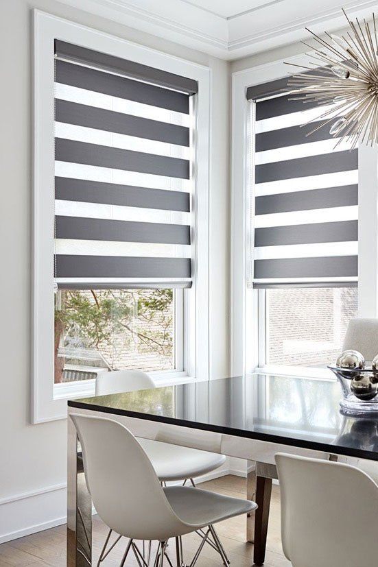 a dining room with striped motorized blinds