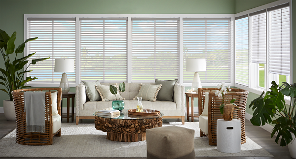 A living room with a couch , chairs , coffee table and blinds.