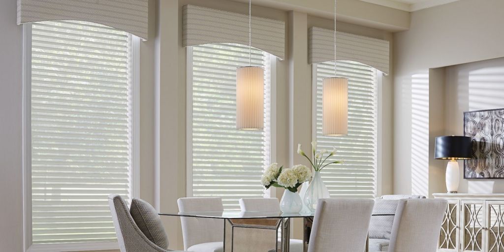 a dining room with window with blinds and top treatments.