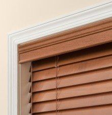 a close up of a standard decorative valance wooden blind on a window .