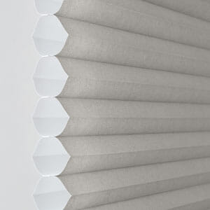 a close up of a cellular 3/4 single cell blind on a window .