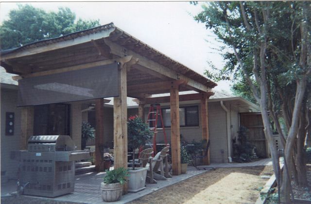 A covered patio with a grill underneath it