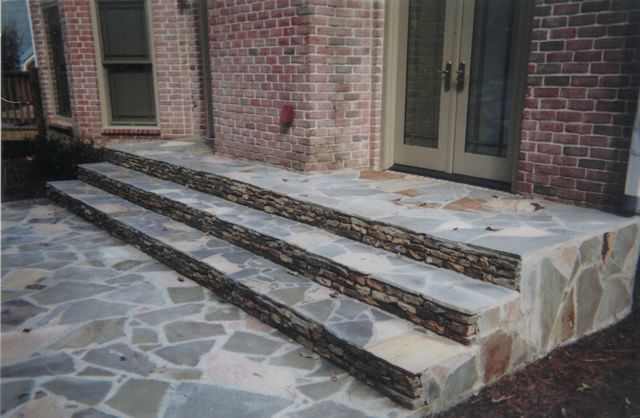 A set of stone steps leading up to a brick building