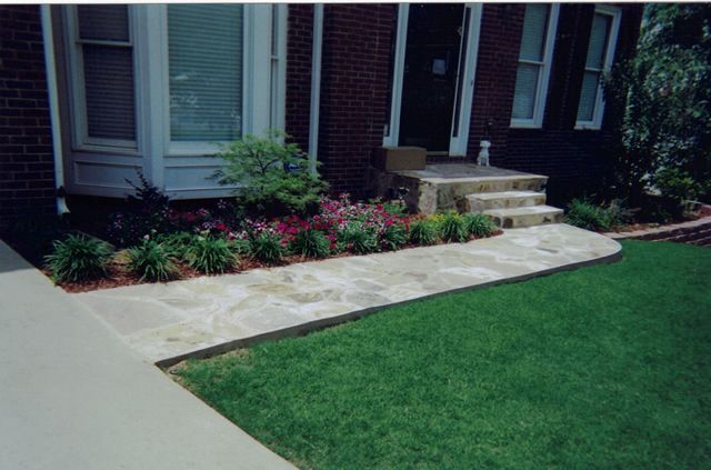 A brick house with a walkway leading to the front door