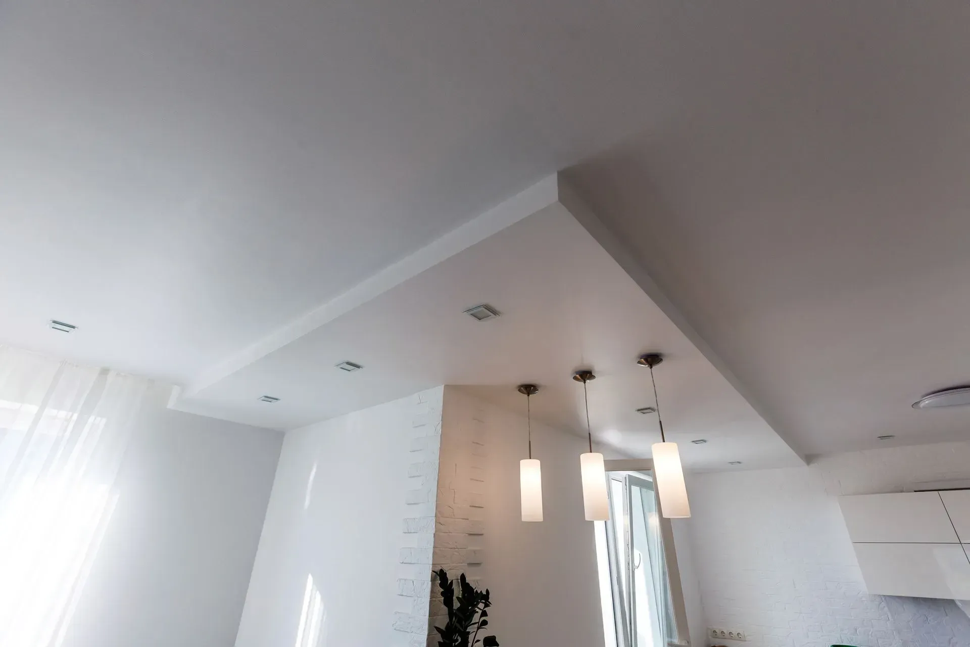 A white ceiling with a lot of lights hanging from it in a living room.