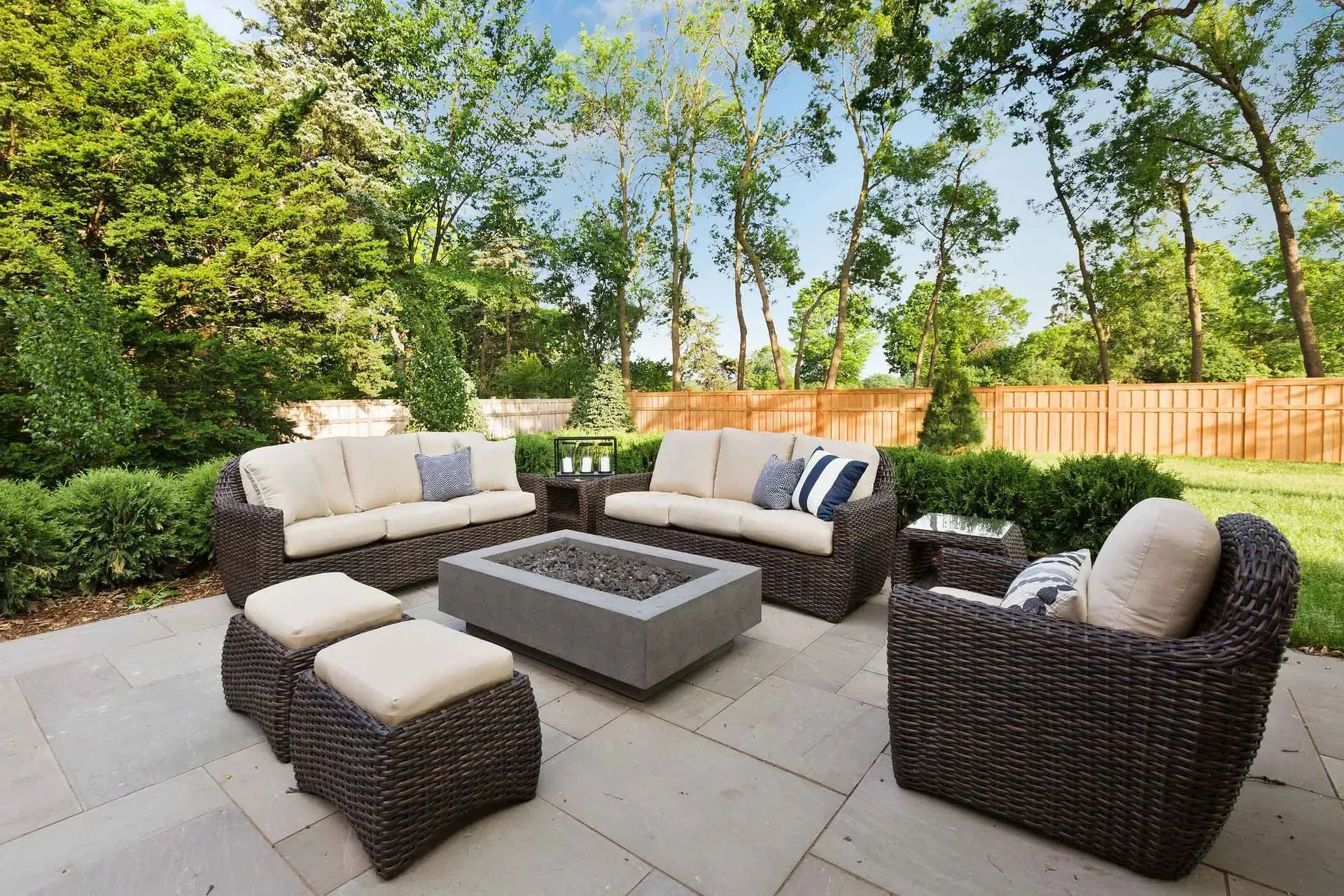 A patio with wicker furniture and a fire pit.
