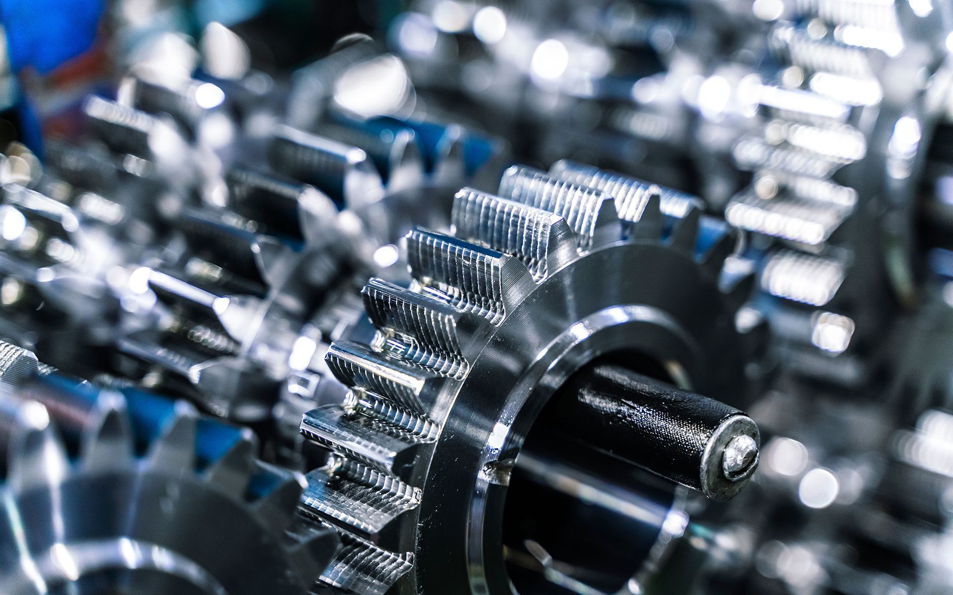 Close-up of shiny, interlocking metal gears in a machine.