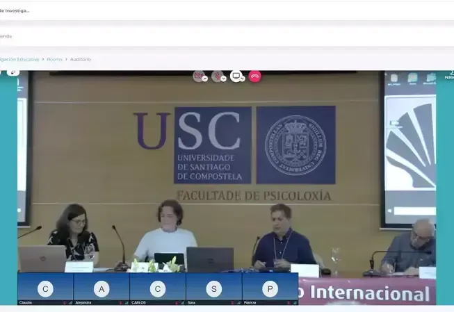Panel discussion at USC, Universidad de Santiago de Compostela, featuring four people at a table, speaking.