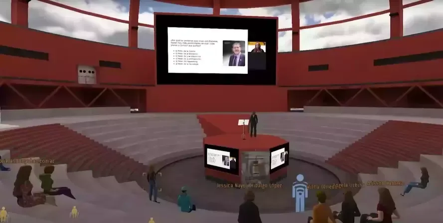 Virtual presentation in a red auditorium; speaker at podium, screen with slides, audience seated.