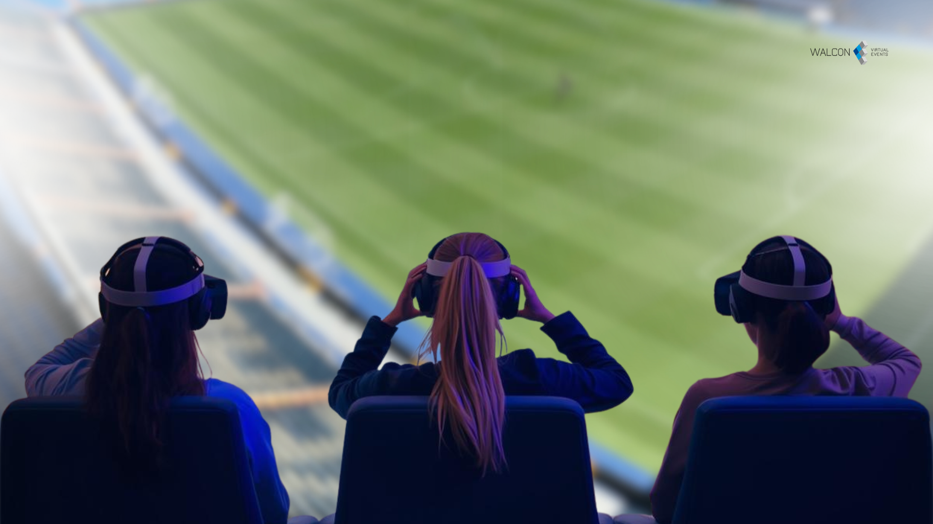 Three people wearing VR headsets watching a sports game in a stadium.