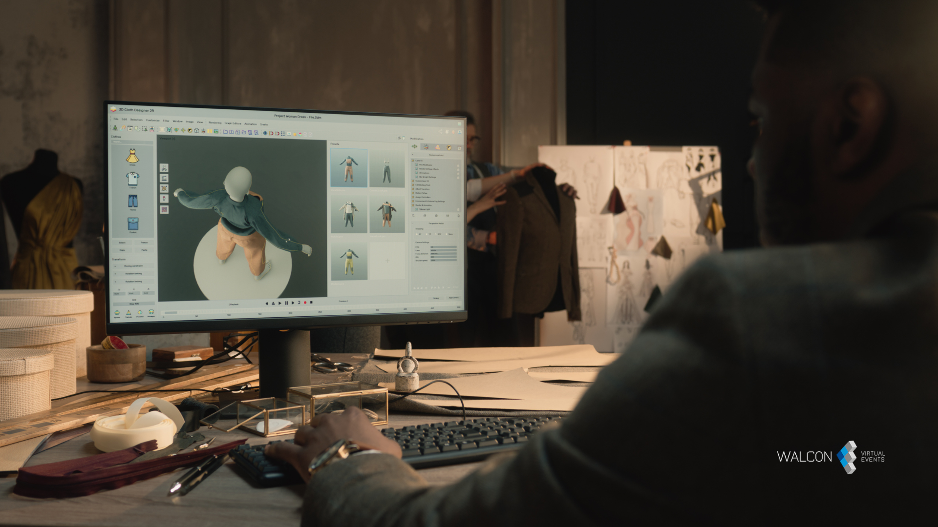 Man editing fashion design on a computer screen in a dimly lit studio.