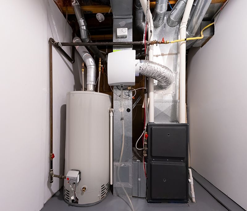 A person in white gloves working on the inner components of a heating system.