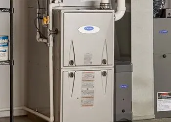 A Carrier furnace and air conditioning unit in a basement utility room.